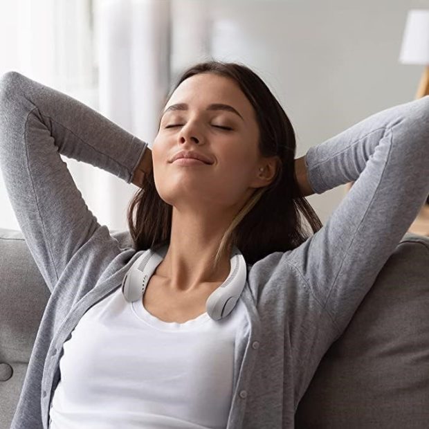 Image of a woman relaxing on the couch with FluxoFlow around her neck